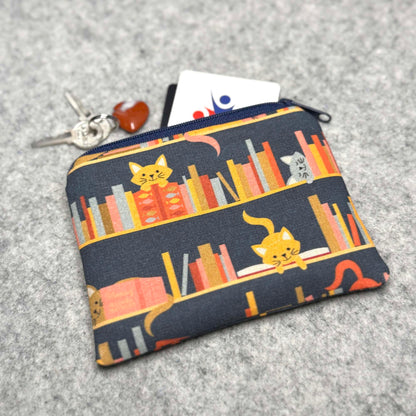 cats on a bookshelf coin pouch