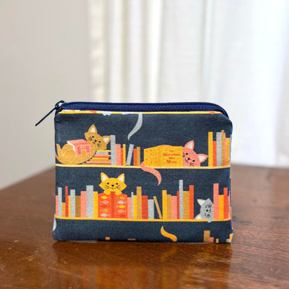 cats on a bookshelf coin pouch