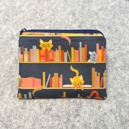 cats on a bookshelf coin pouch