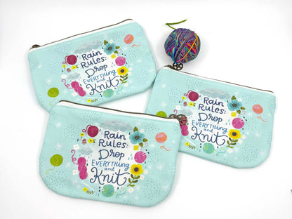 blue green canvas zippered pouch printed with yarn and flowers that says "rain rules drop everything and knit" 